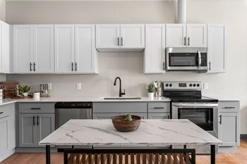 a kitchen with white cabinets and stainless steel appliances